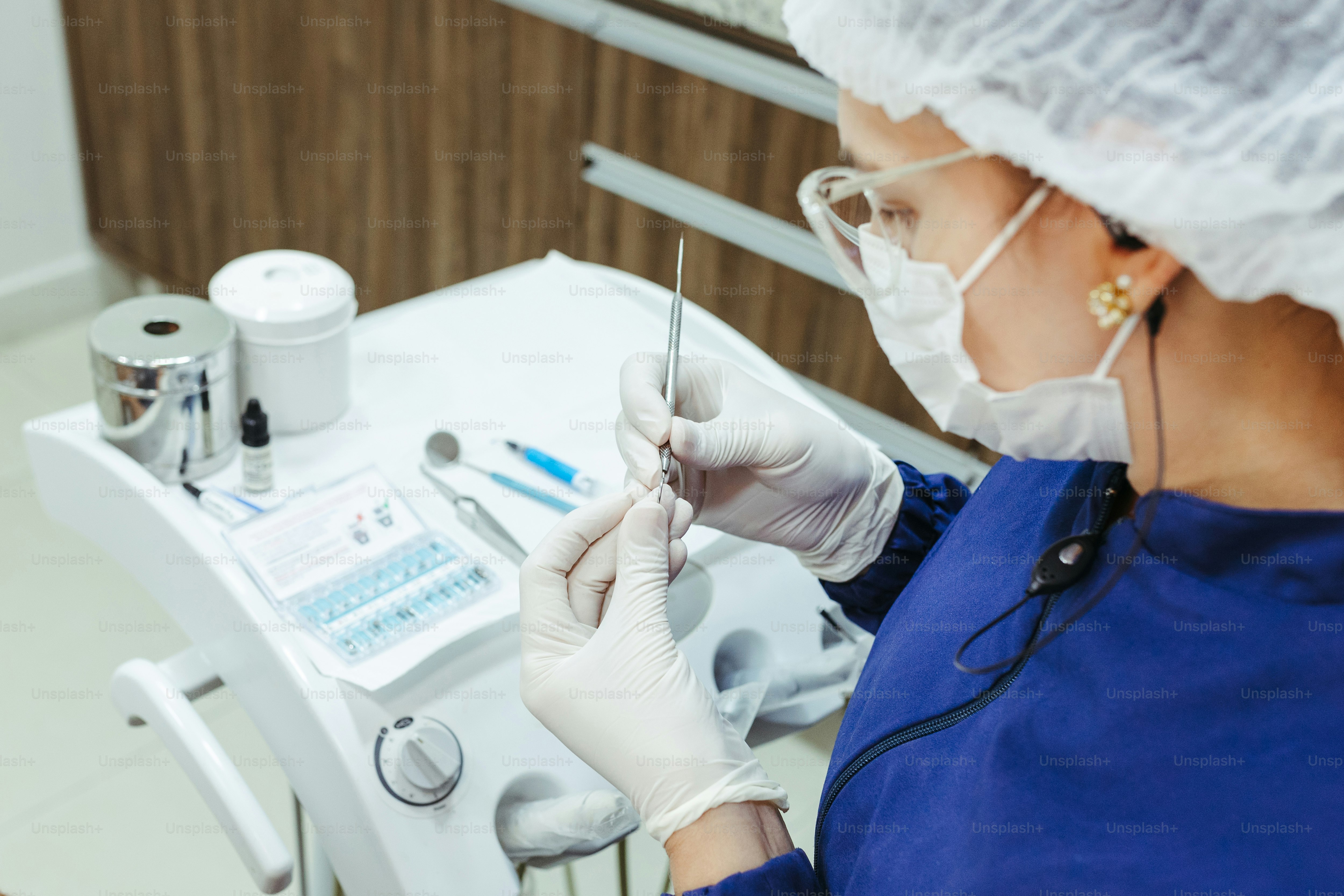a woman in a surgical gown is doing a procedure