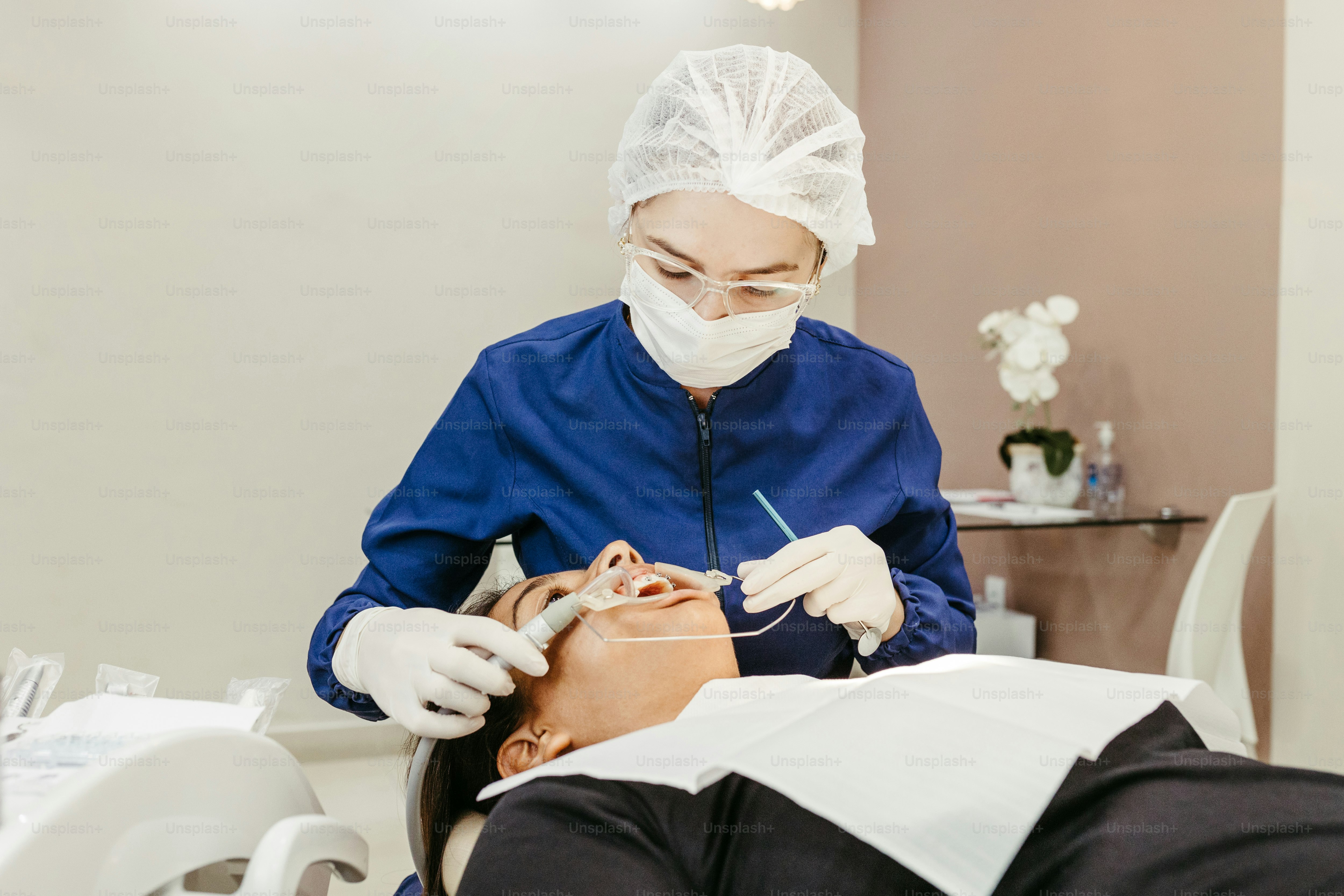 a woman getting her teeth checked by a dentist