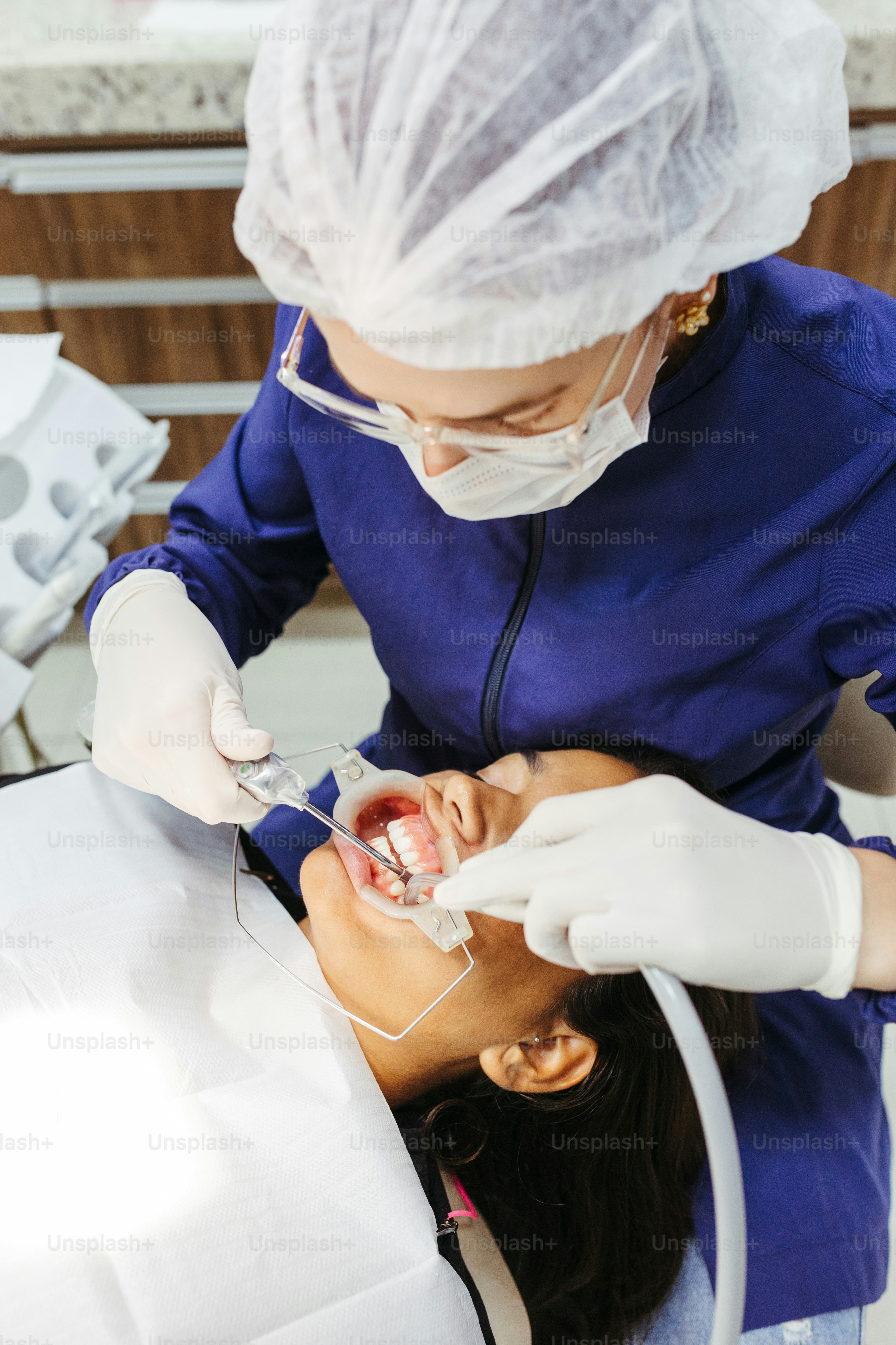 a woman getting her teeth checked by a dentist