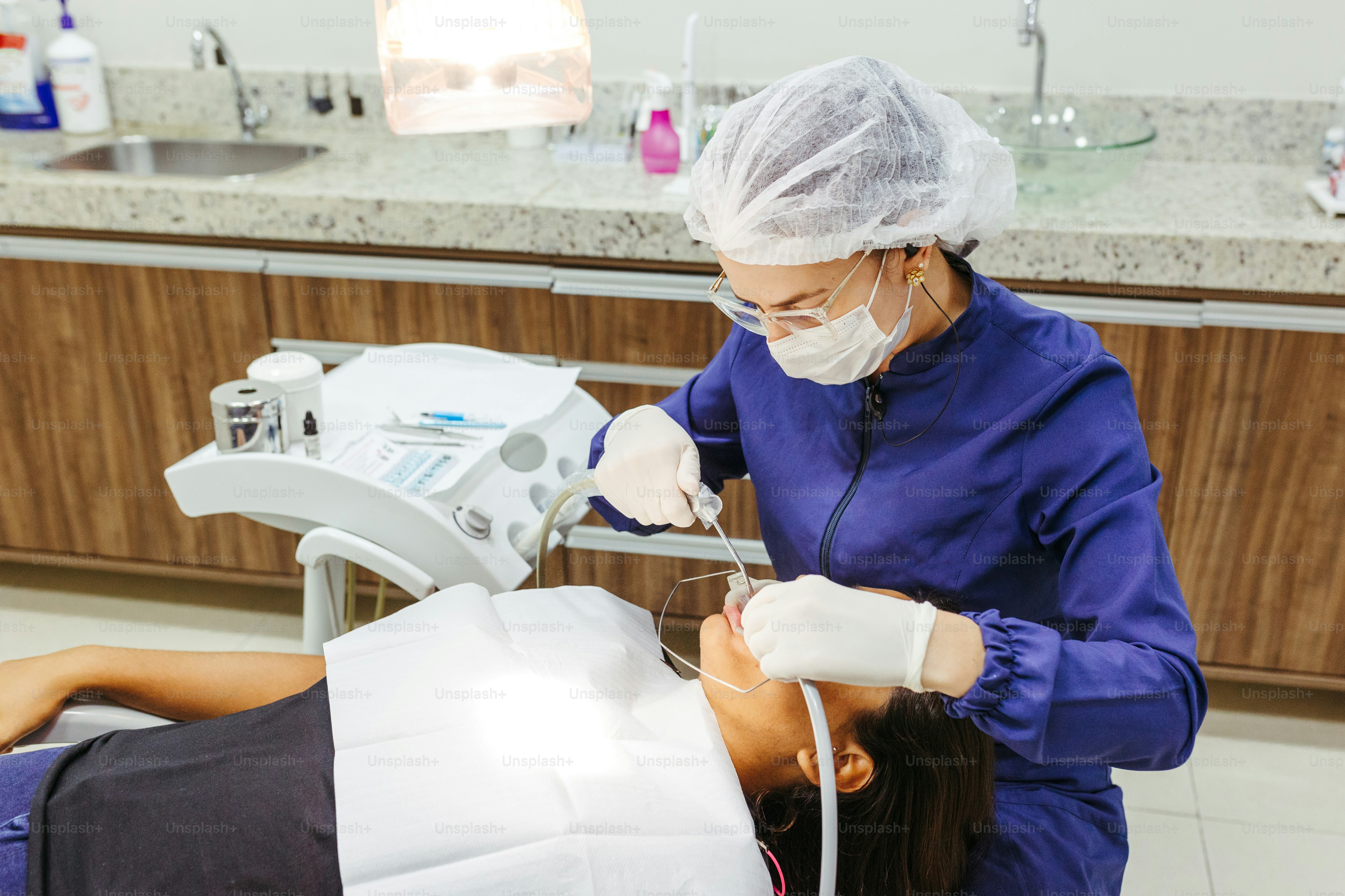 a woman getting her teeth checked by a dentist