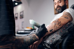 Ein Mann bekommt ein Tattoo auf seinem Arm
