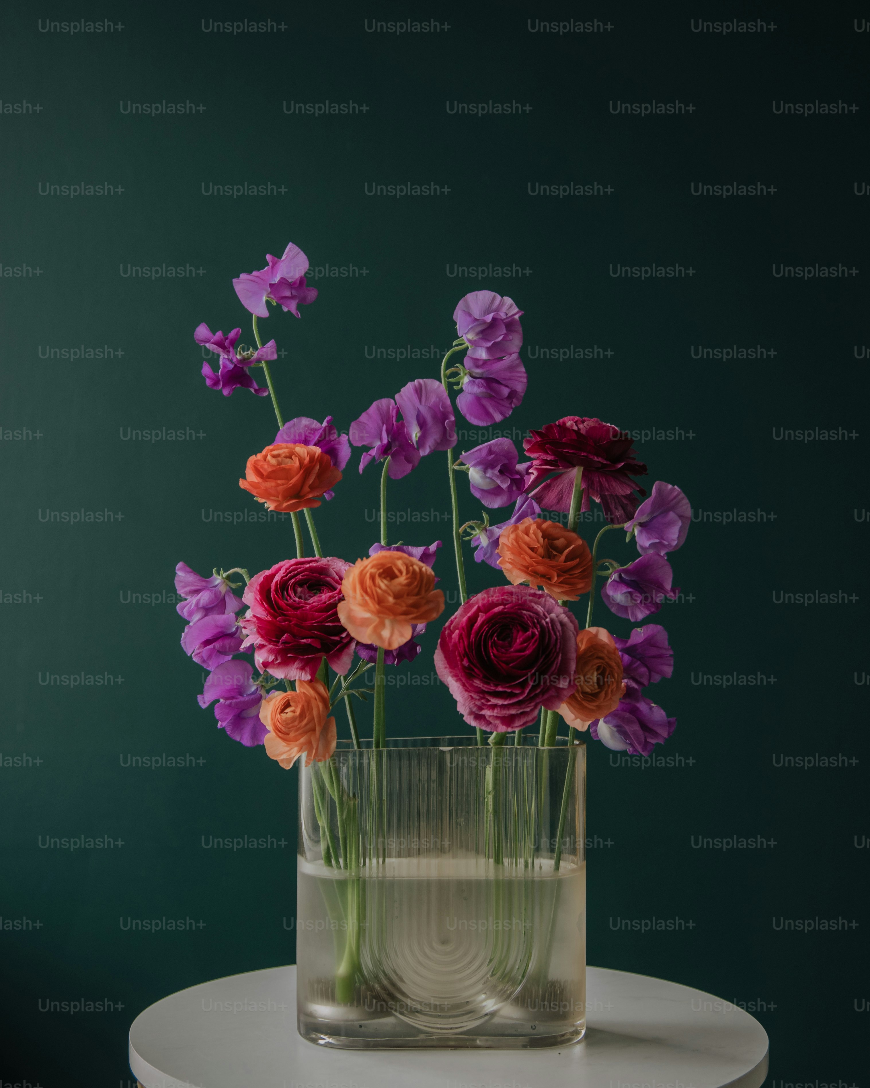 a glass vase filled with colorful flowers on top of a table