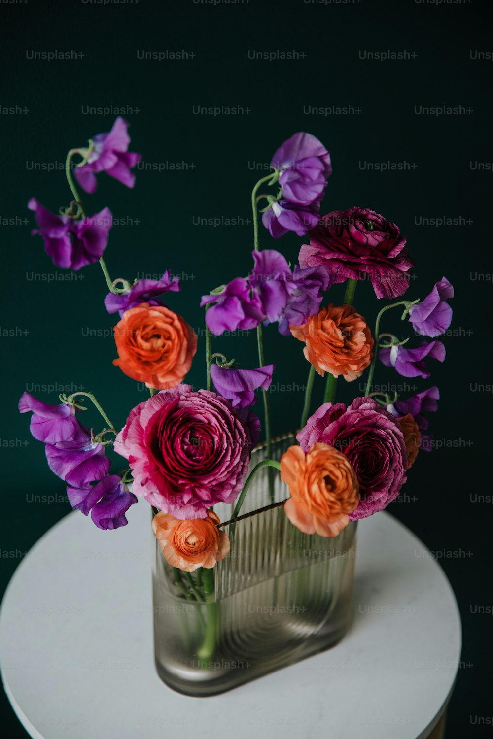 a vase filled with purple and orange flowers