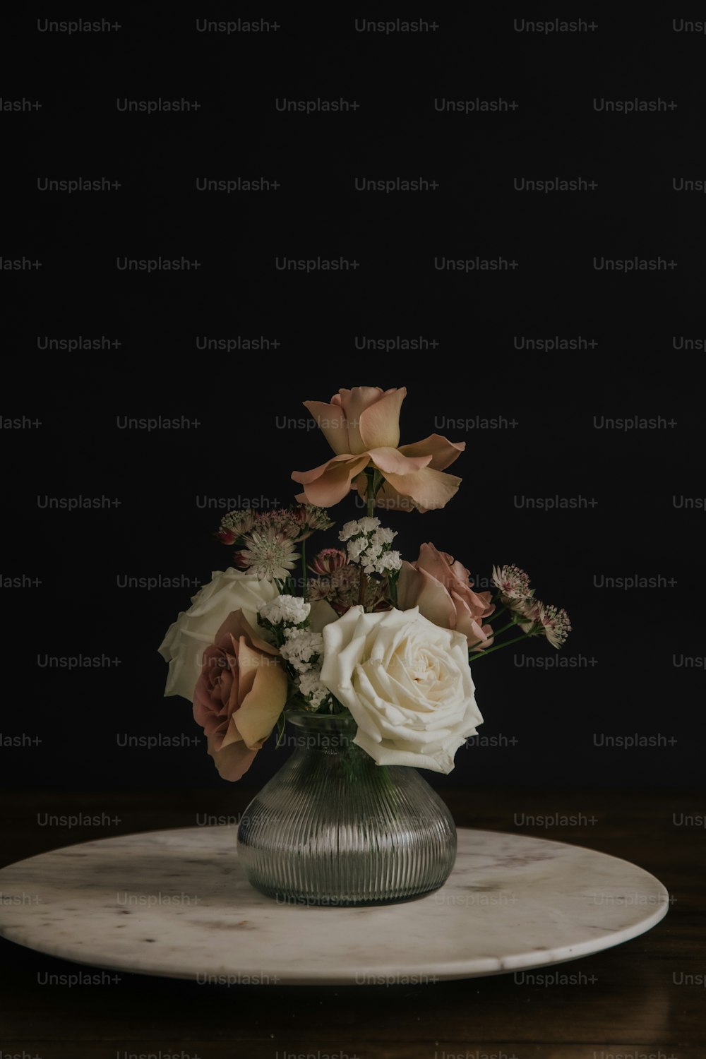 a glass vase filled with white and pink flowers