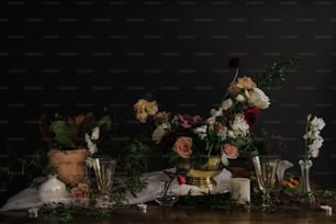Una mesa cubierta con jarrones llenos de flores y velas