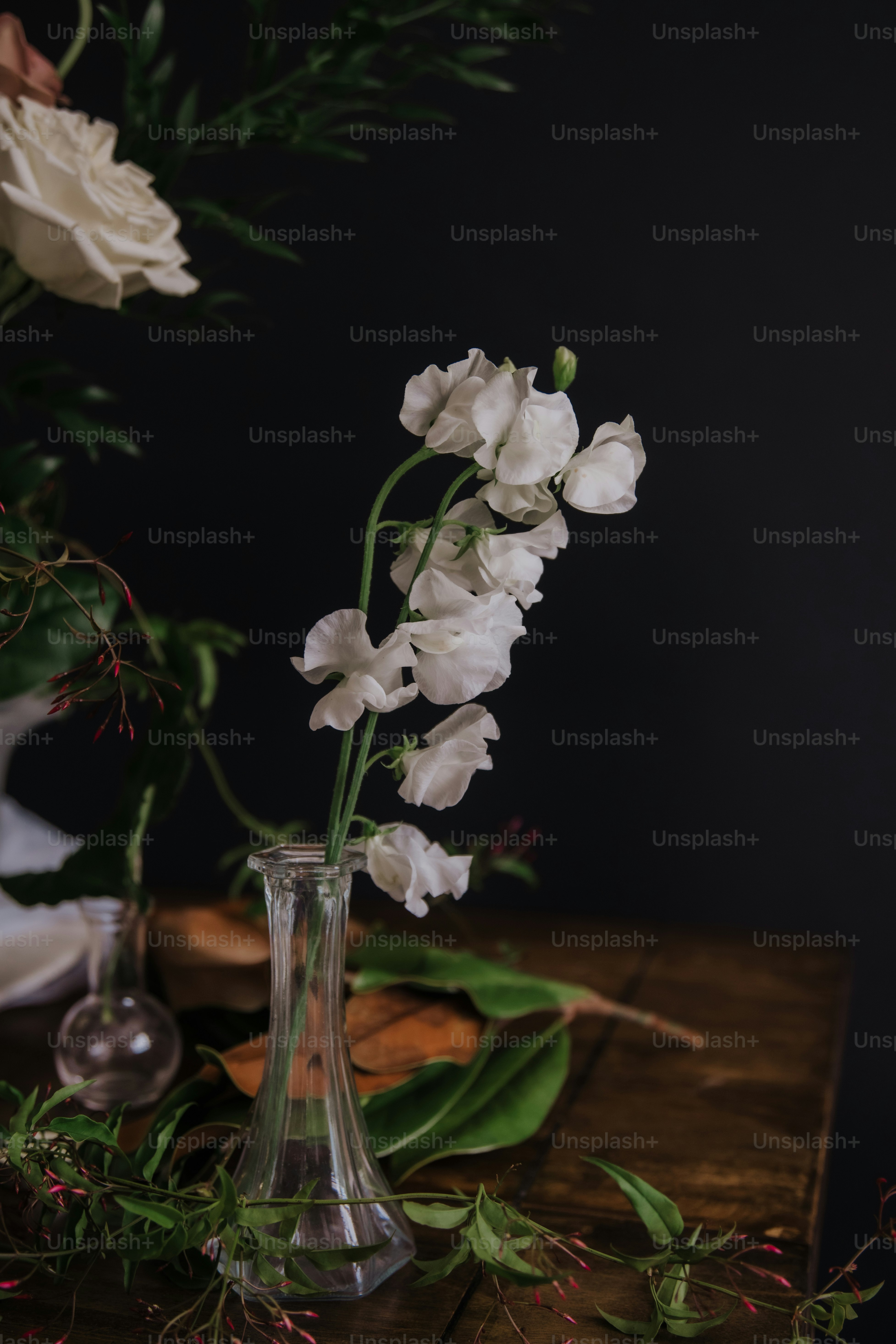 a vase filled with white flowers on top of a wooden table
