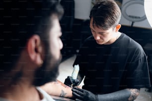 um homem fazendo uma tatuagem em seu braço