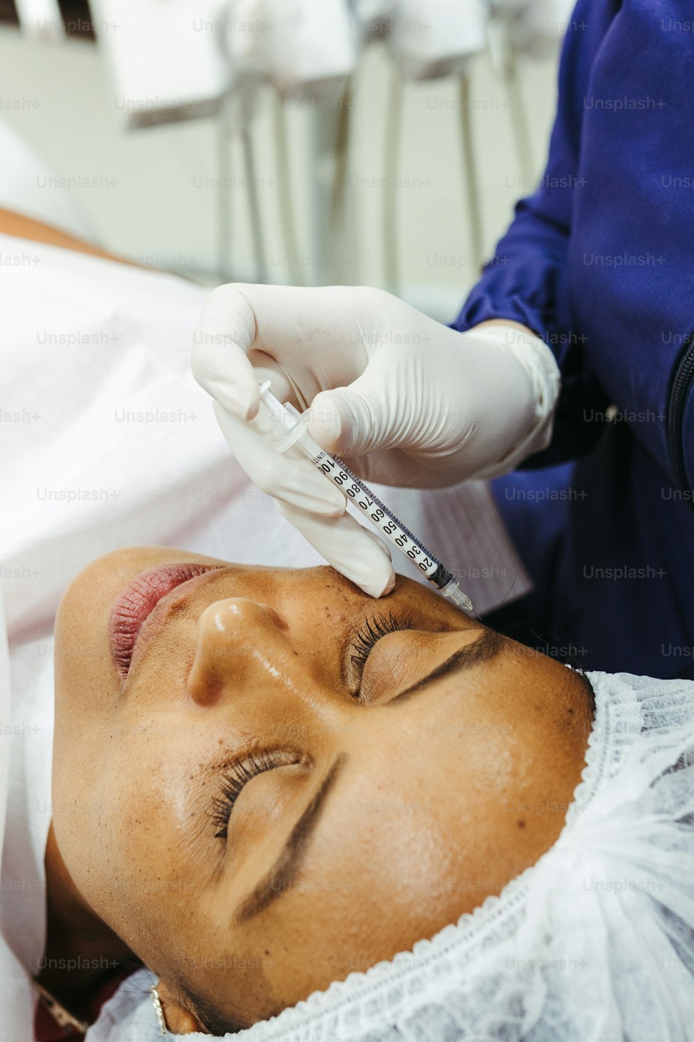 a woman getting her eyebrows examined by a doctor