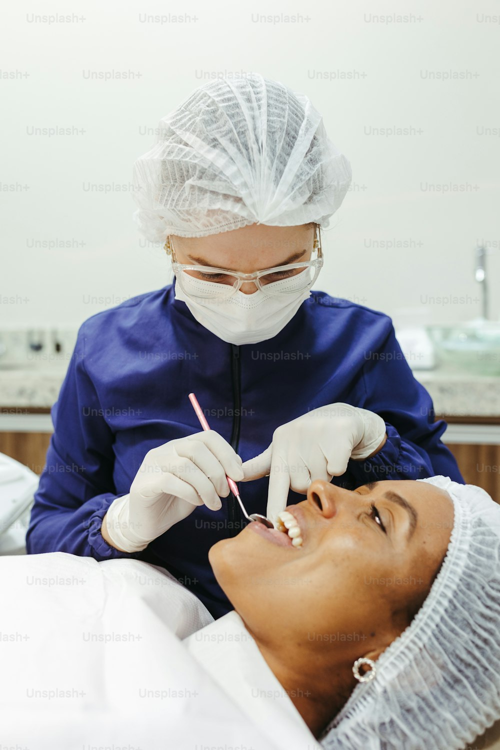 Una mujer que se revisa los dientes por un dentista