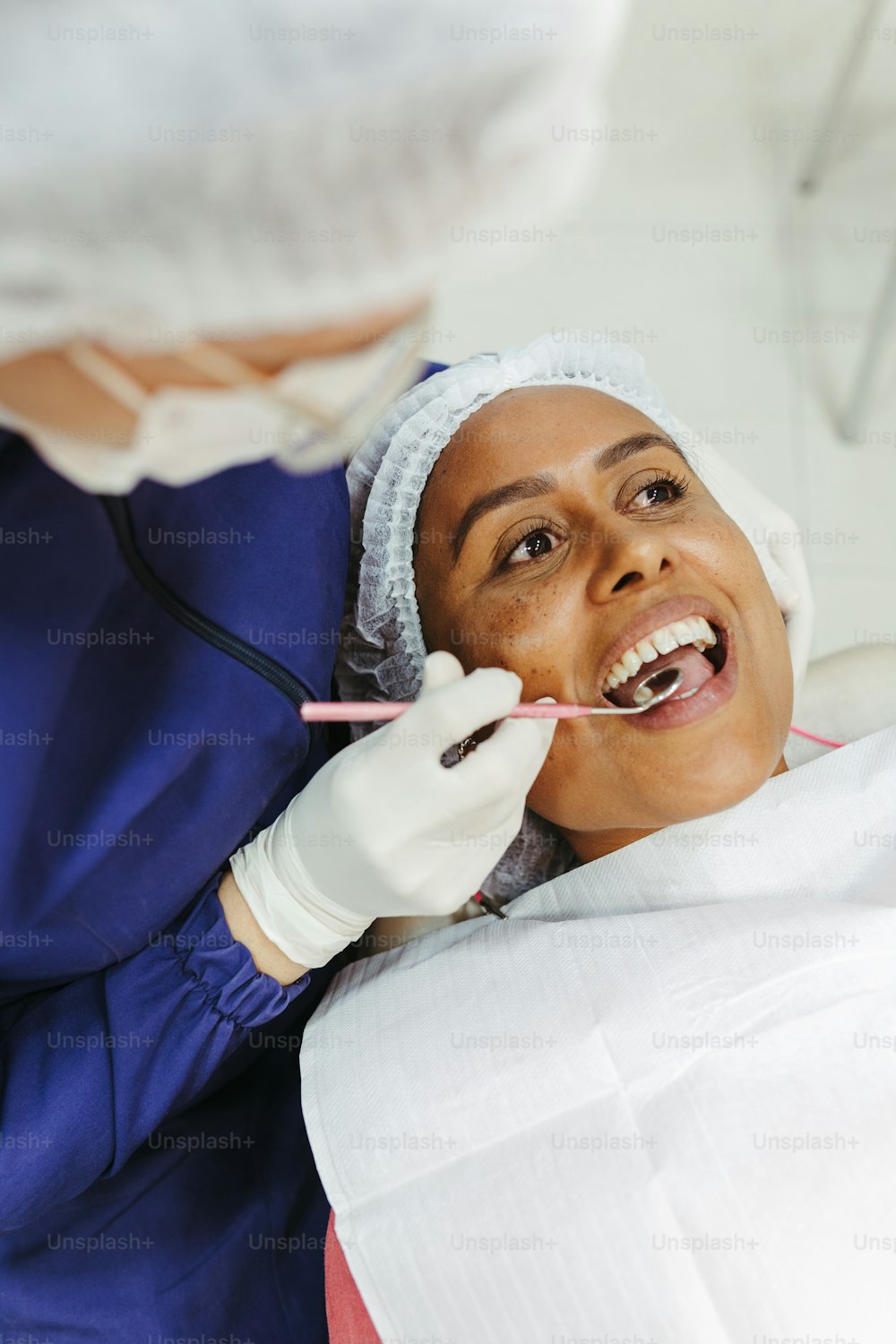 uma mulher que verifica os dentes por um dentista