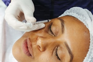 a woman getting her eyebrows examined by a doctor