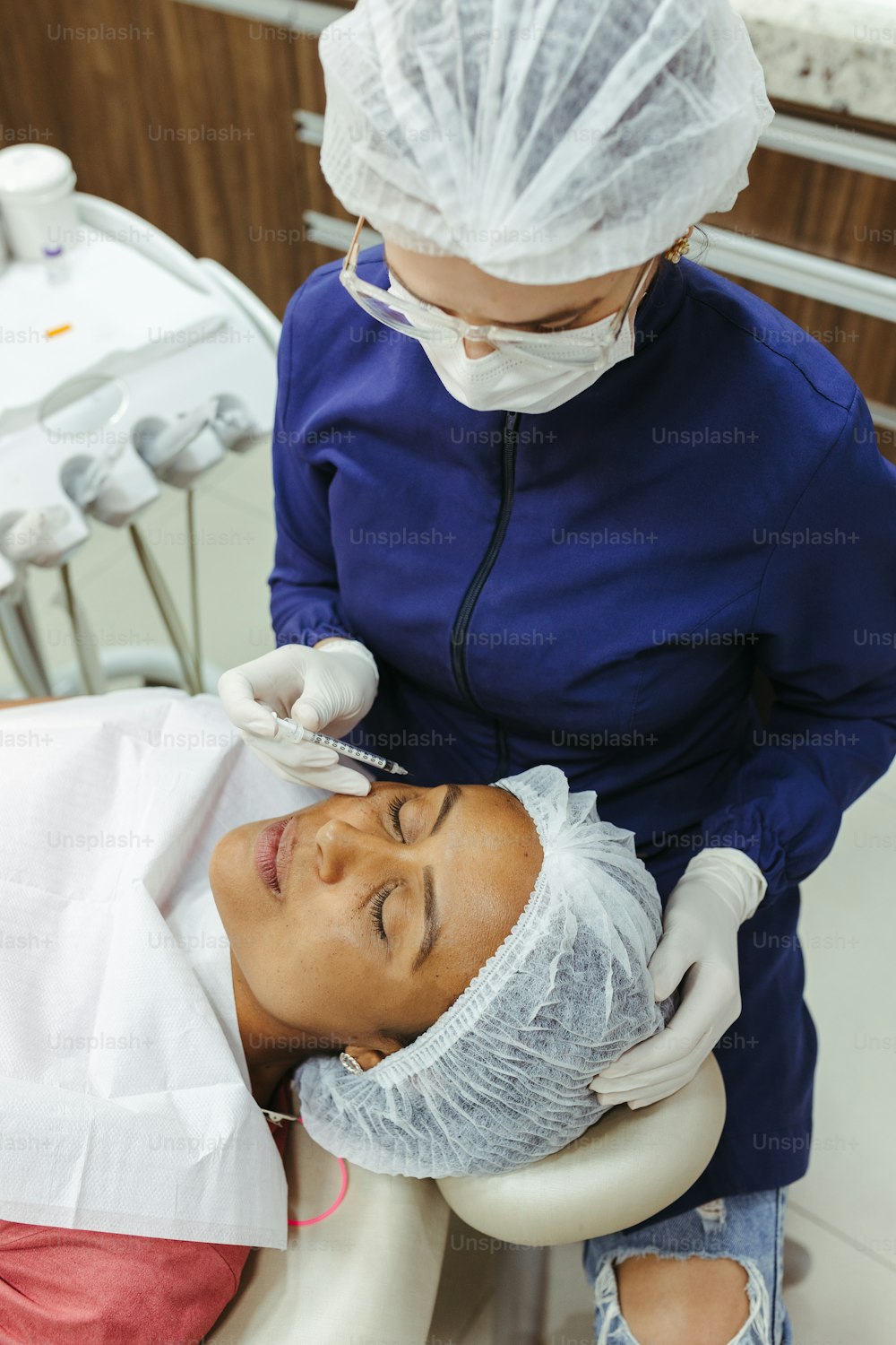 a woman getting her teeth checked by a dentist