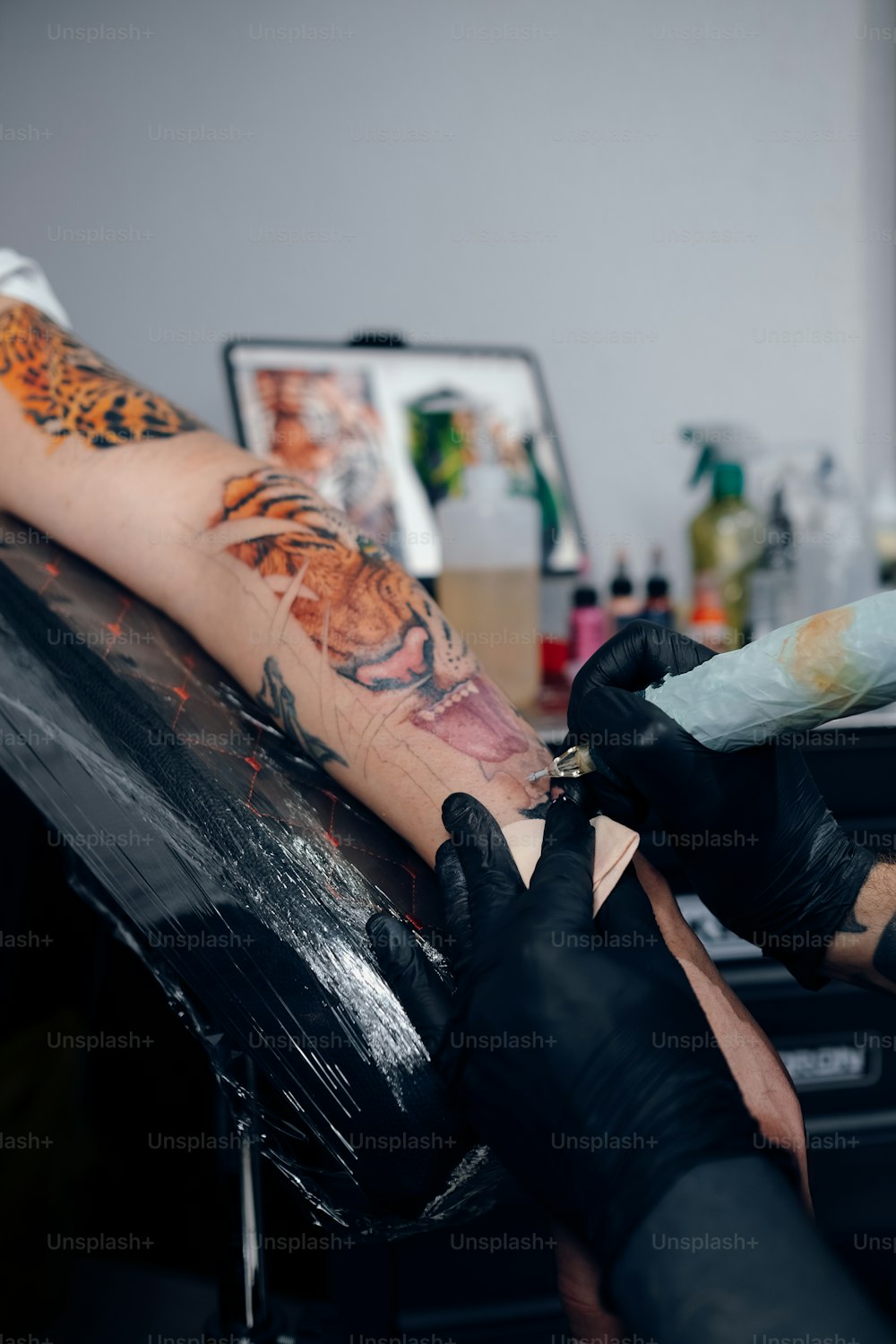 une personne se faisant tatouer le bras d’une autre personne