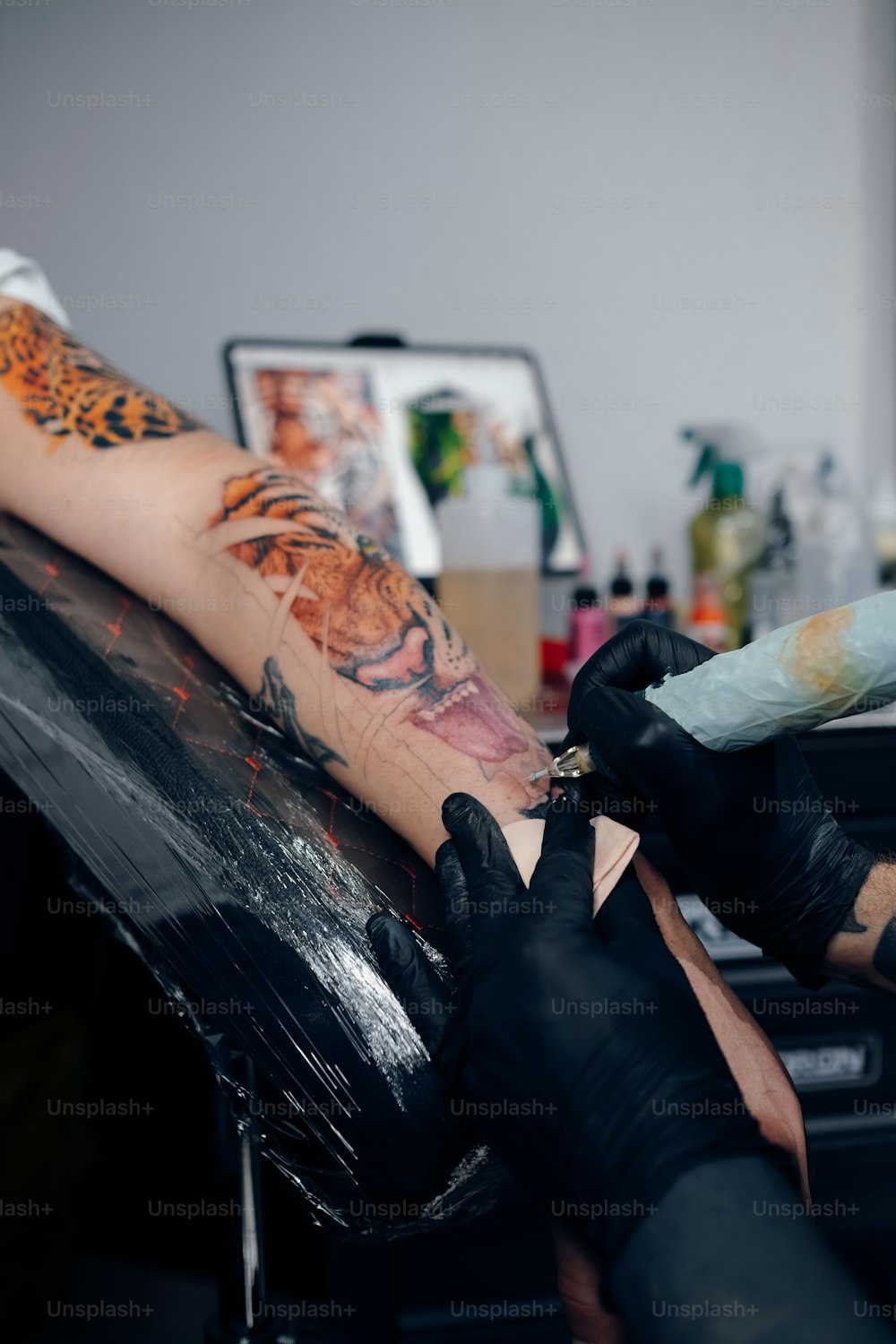 a person getting a tattoo on another person's arm
