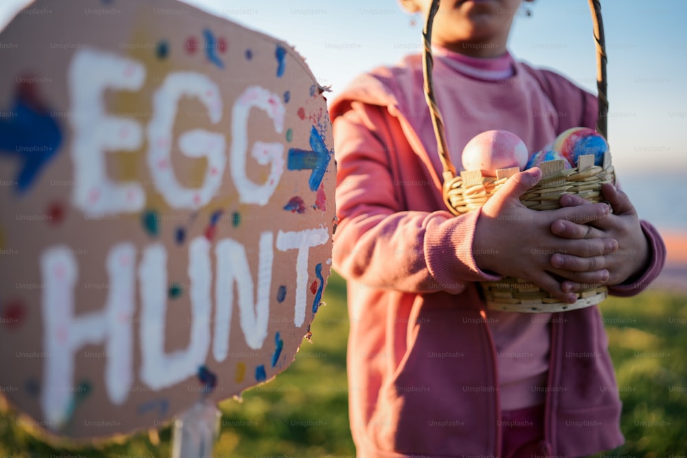 Una niña pequeña sosteniendo una canasta de huevos