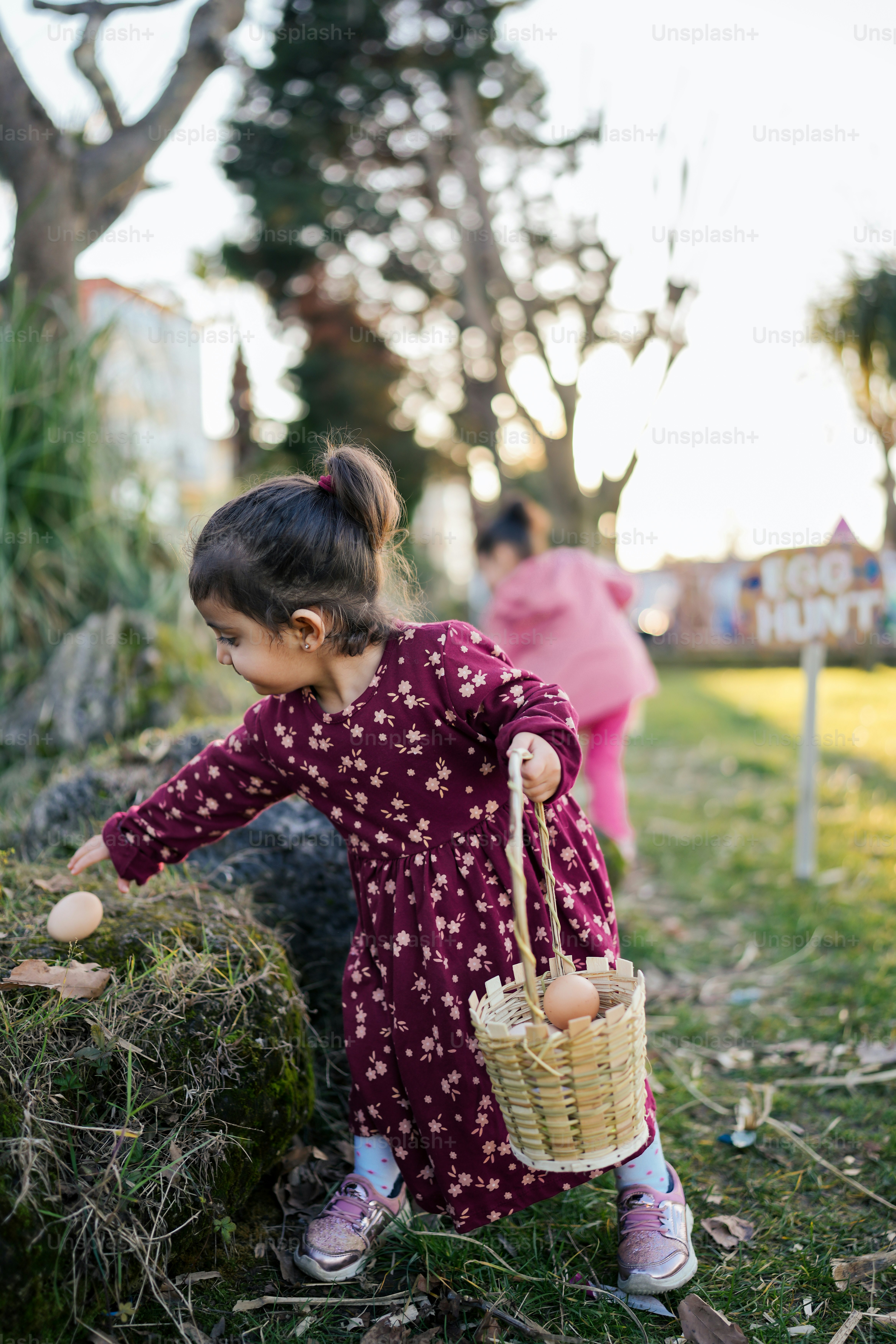 a little girl in a purple dress holding a basket