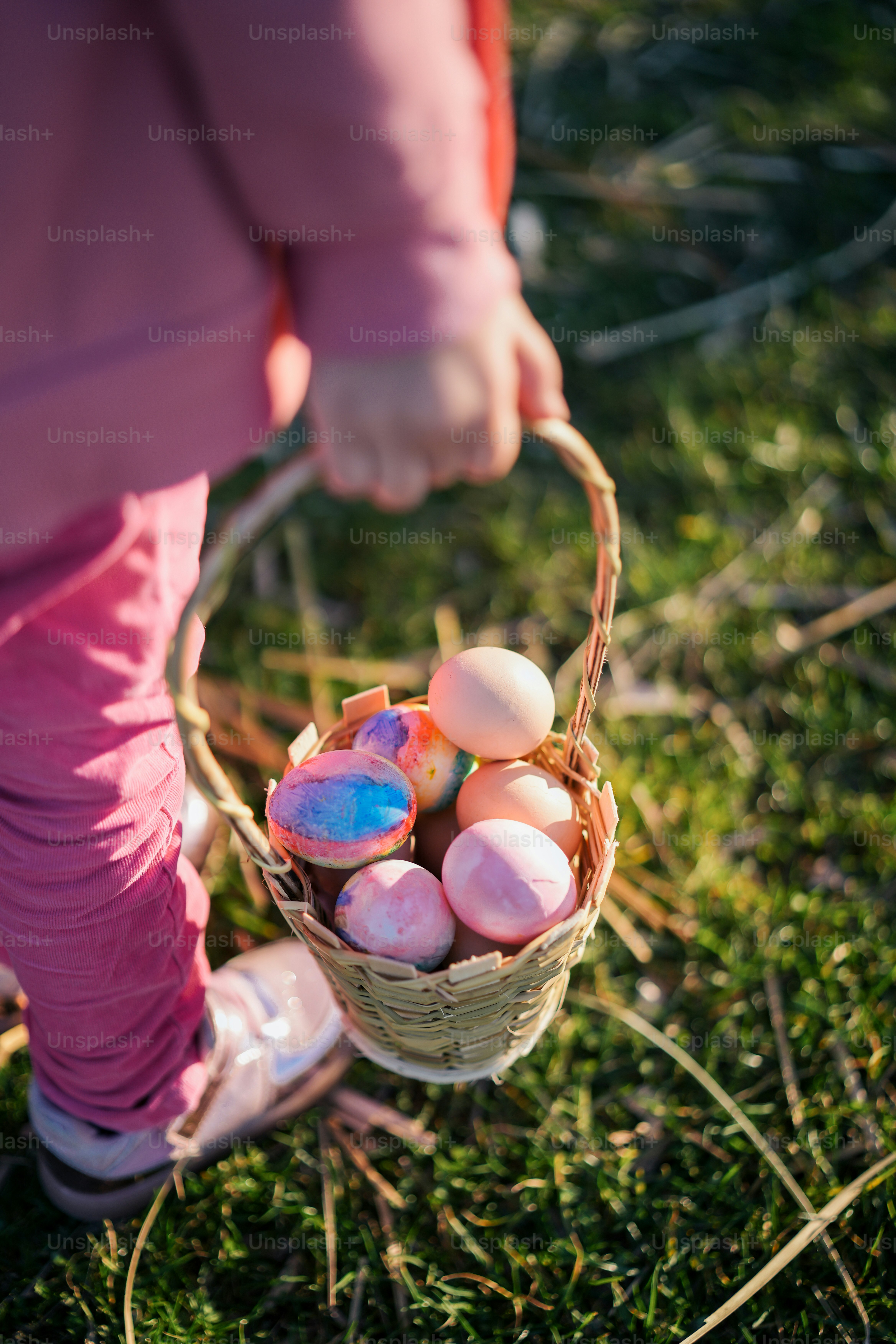 a little girl holding a basket full of eggs