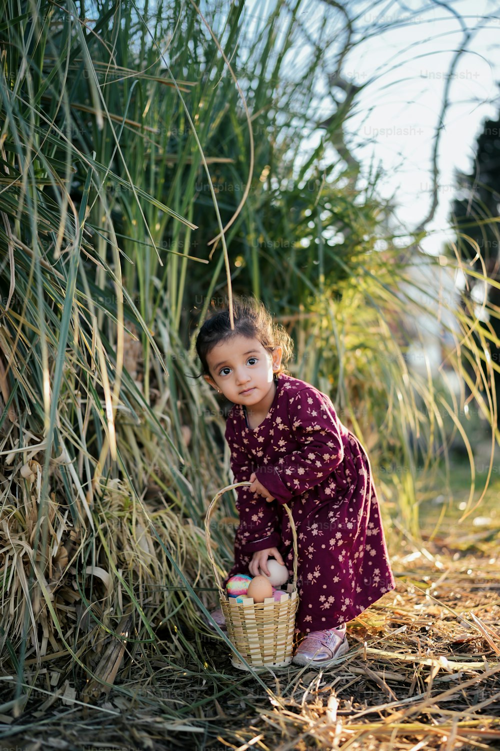 Ein kleines Mädchen hält einen Korb voller Eier