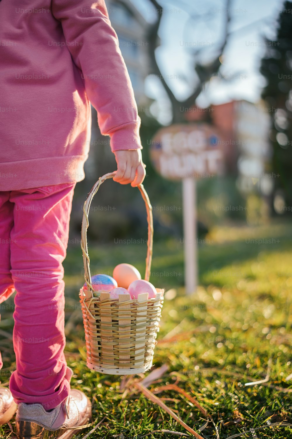 a little girl holding a basket full of eggs