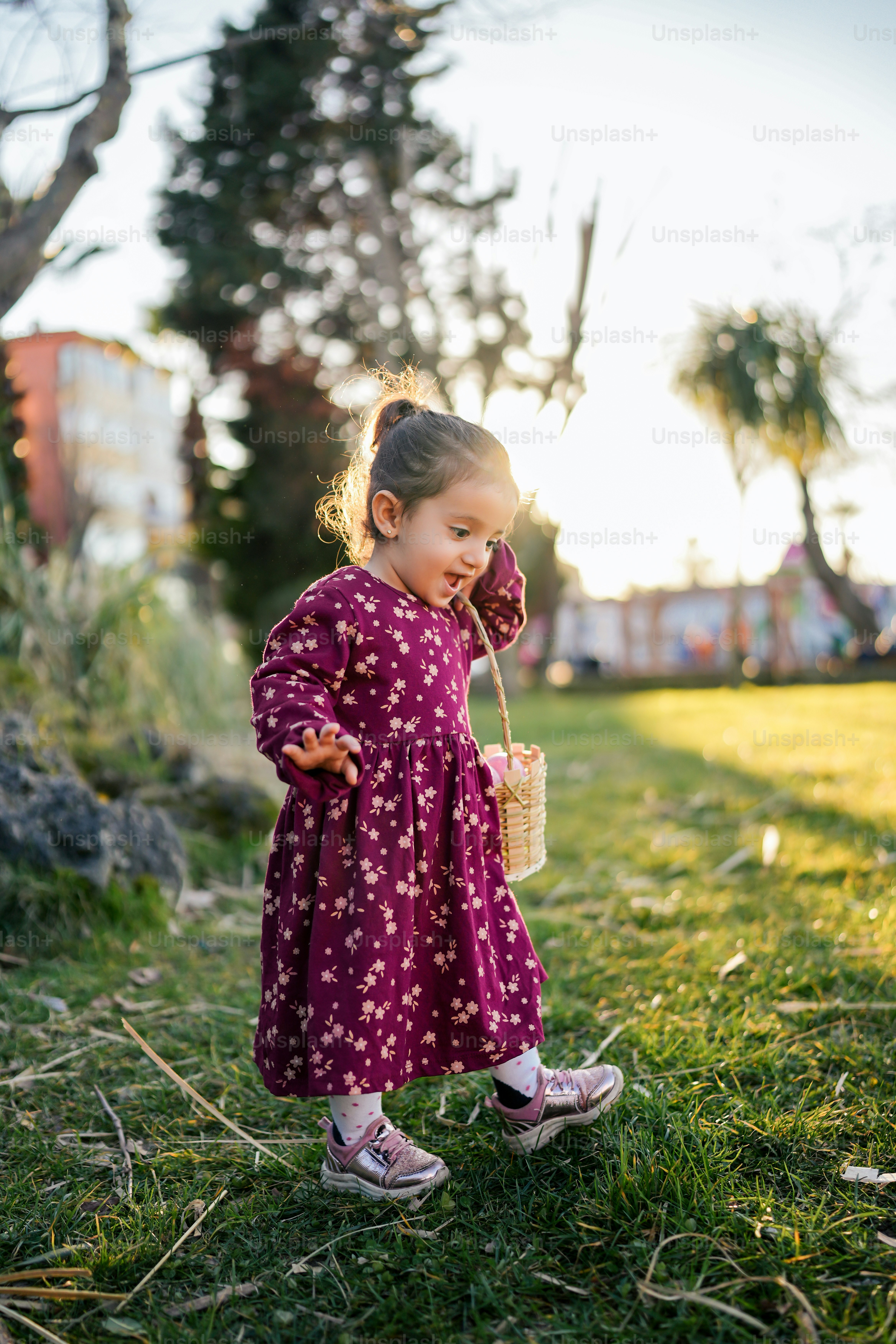 a little girl in a purple dress holding a basket
