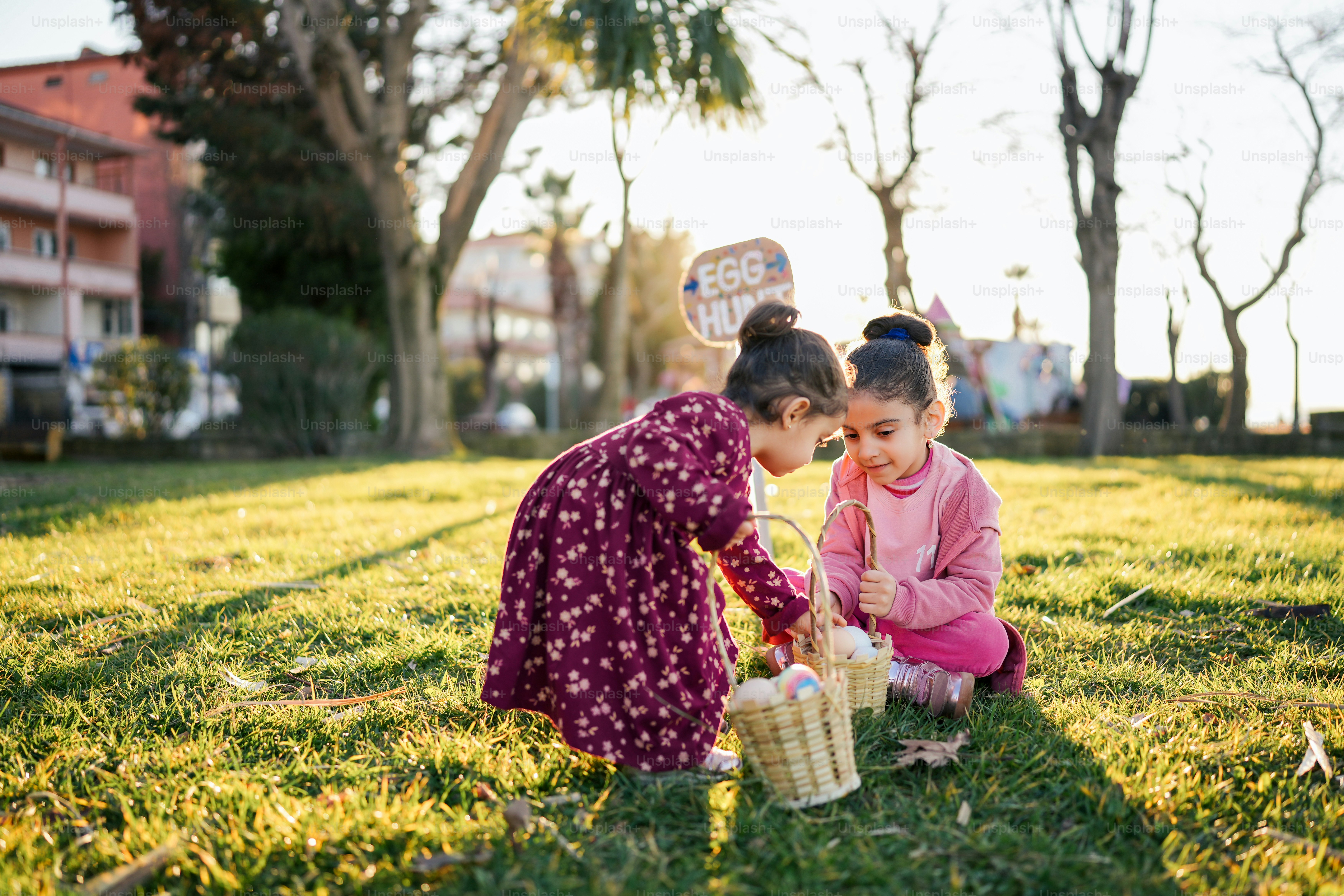 two young girls are playing with a basket of eggs