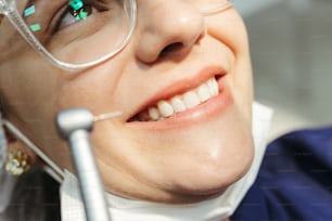 une femme avec des lunettes et une brosse à dents dans la bouche