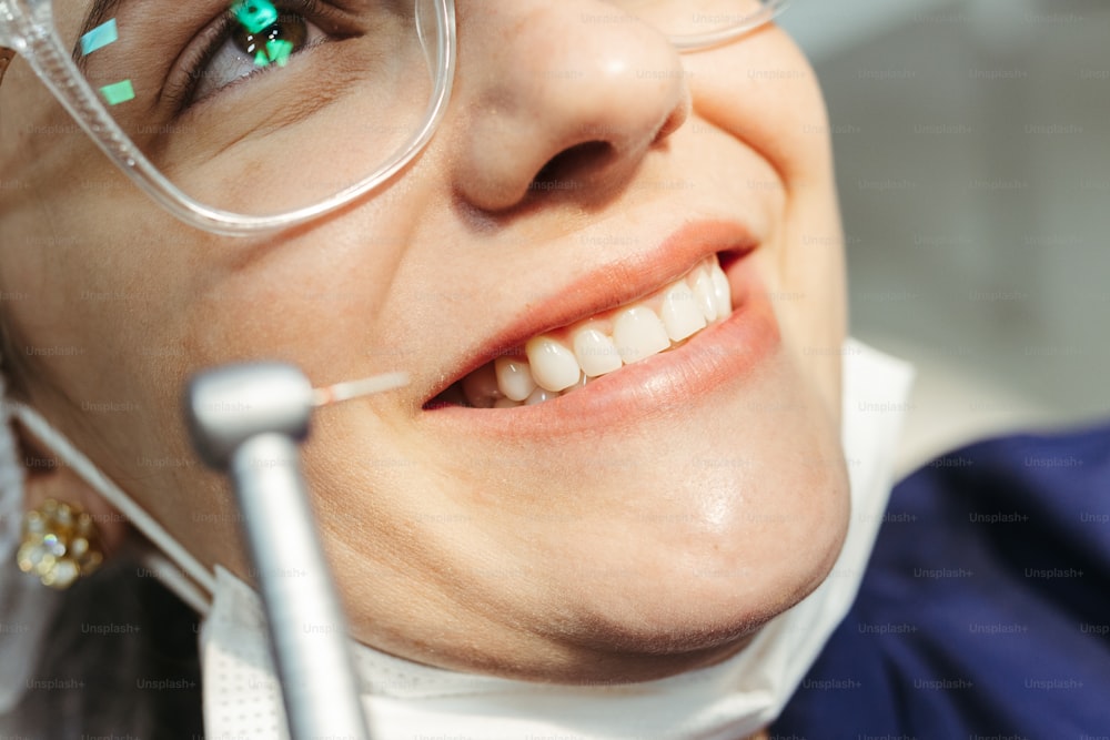 Eine Frau mit Brille und Zahnbürste im Mund