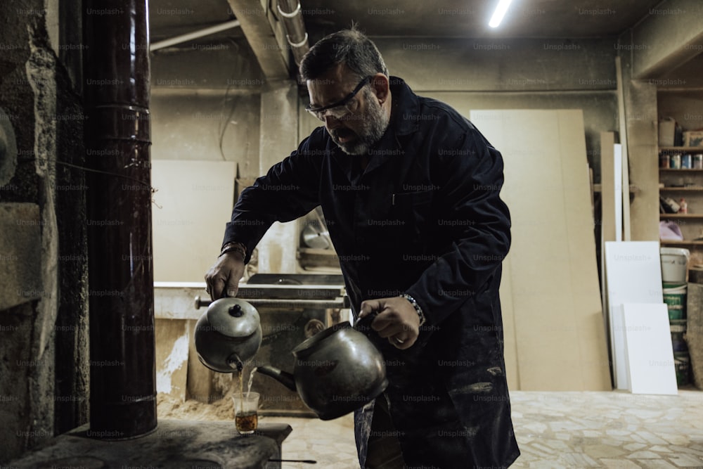 a man pouring water into a tea pot