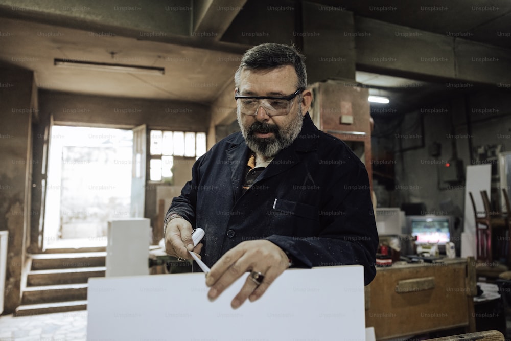 a man with a beard and glasses working on a piece of paper