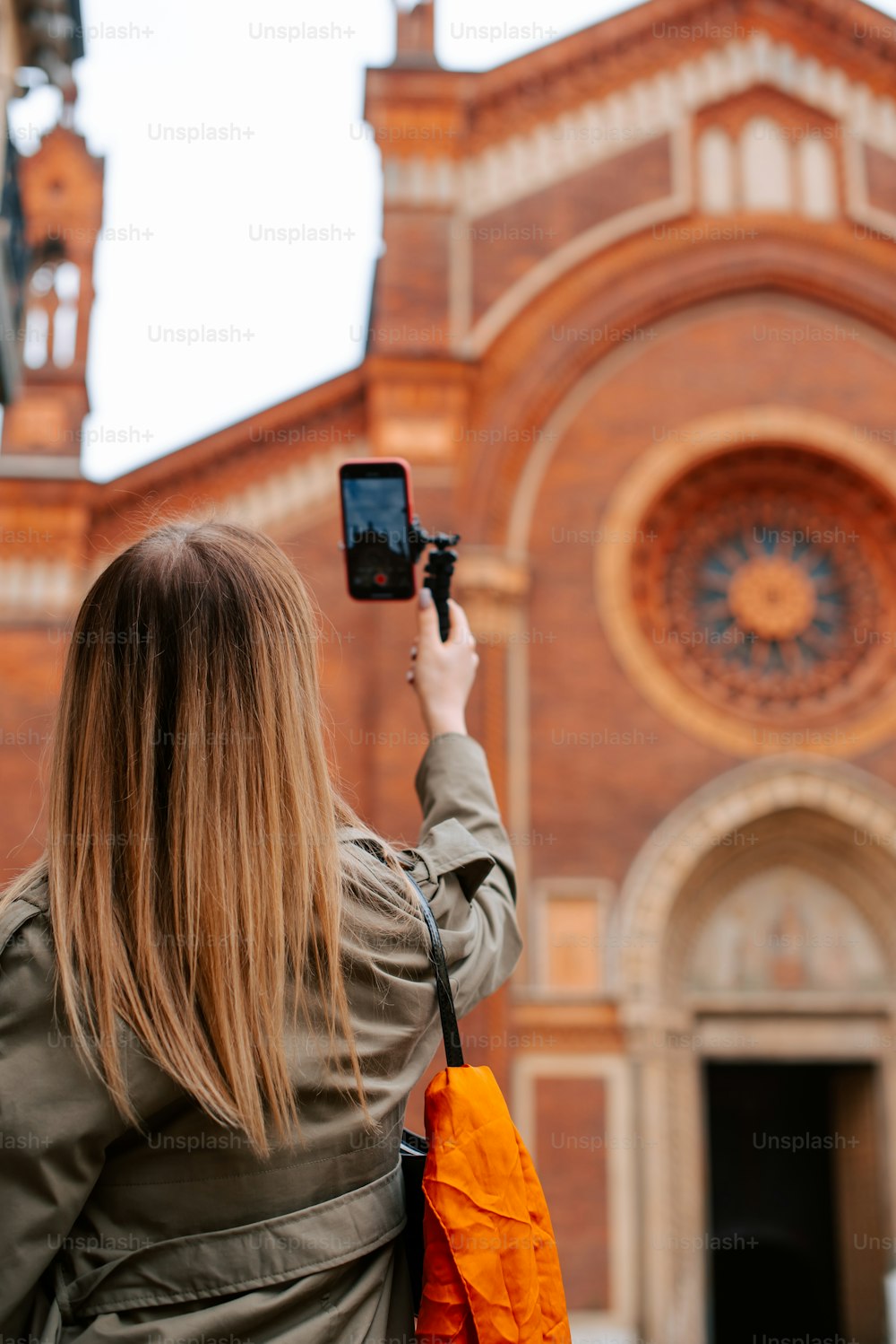 携帯電話で建物の写真を撮る女性