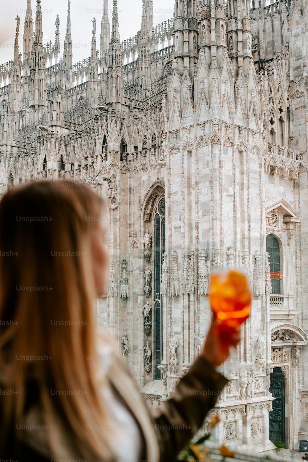 a woman holding an orange frisbee in front of a building