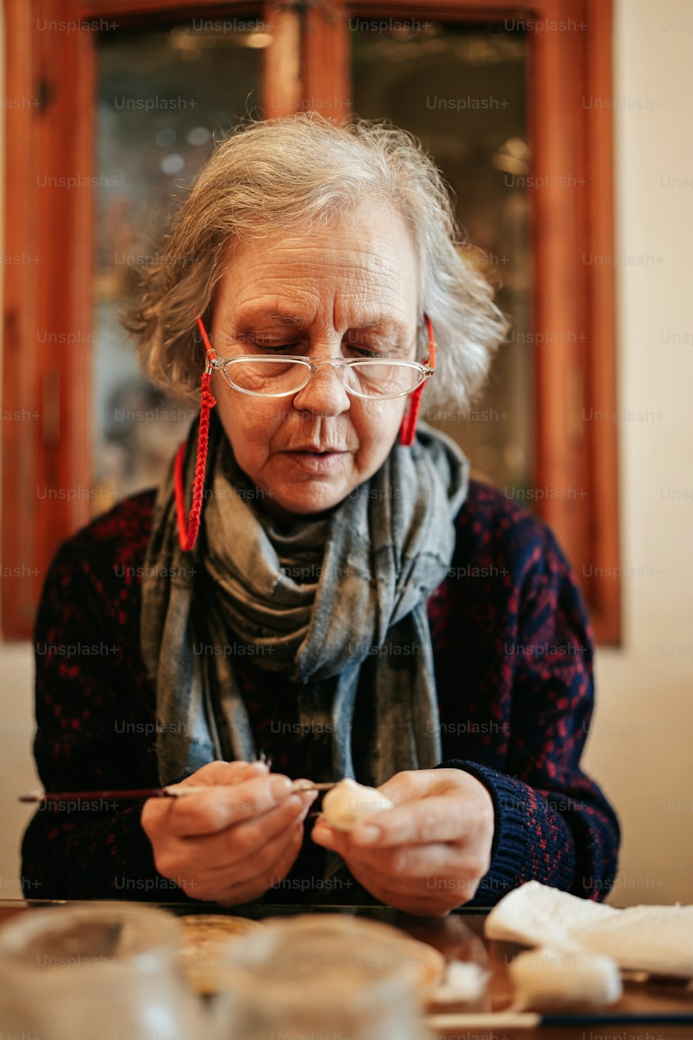 Una donna anziana che porta gli occhiali e una sciarpa