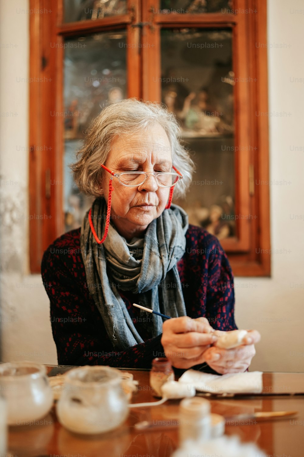 uma mulher sentada em uma mesa com um pedaço de papel na mão