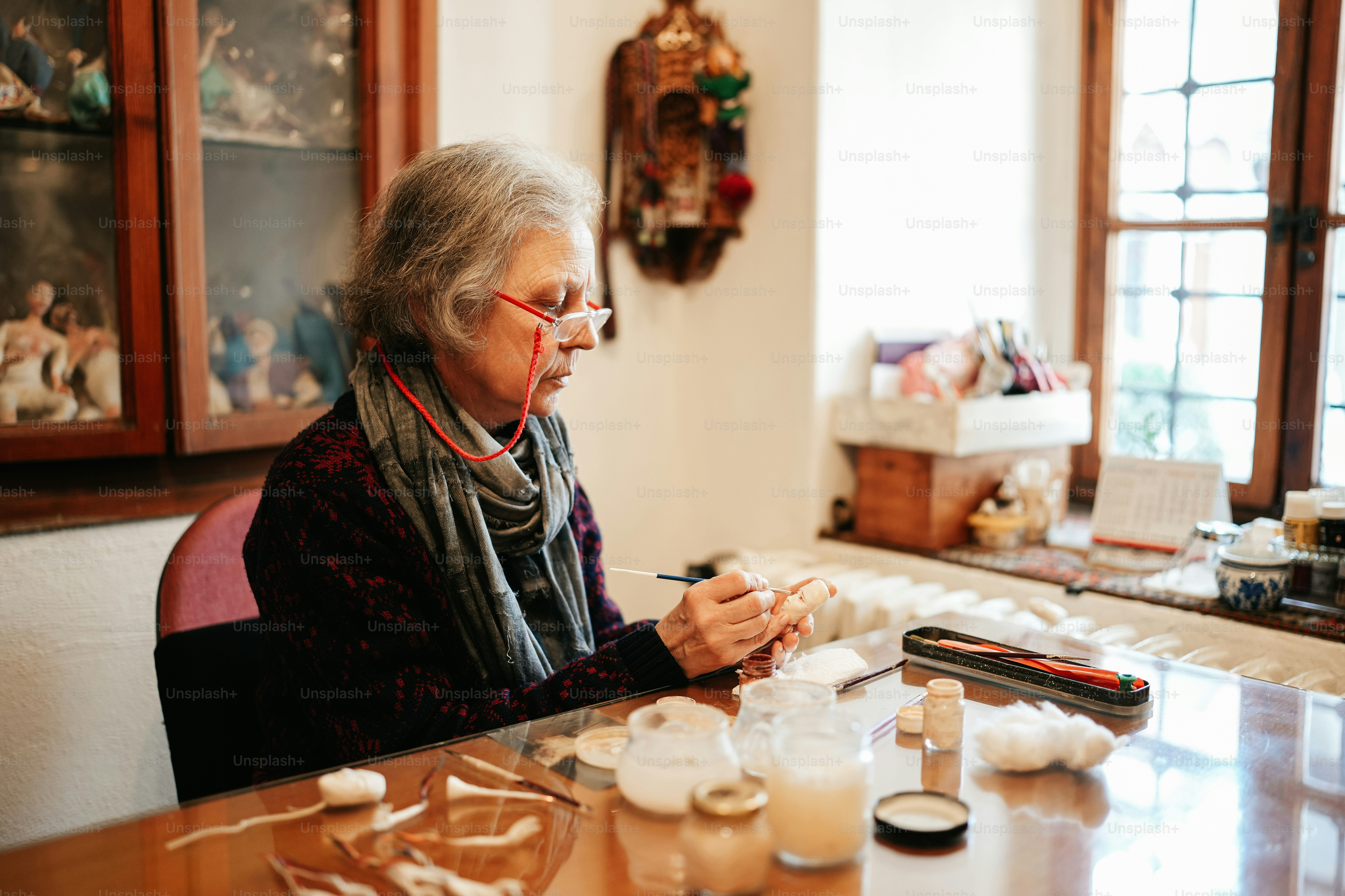 Eine Frau sitzt mit einem Handy an einem Tisch