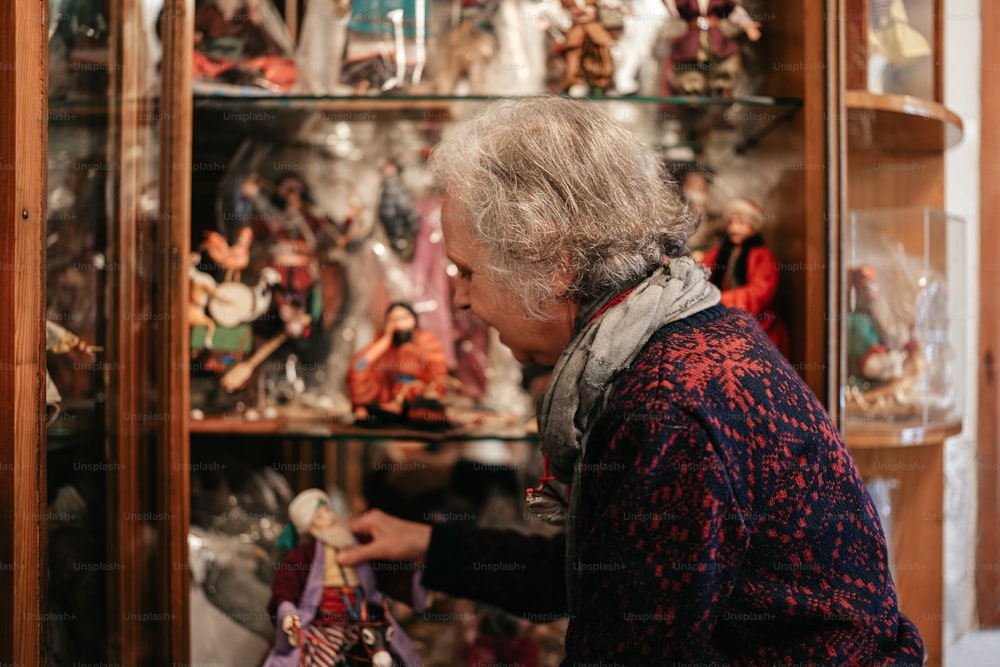 a woman looking at a display case full of figurines