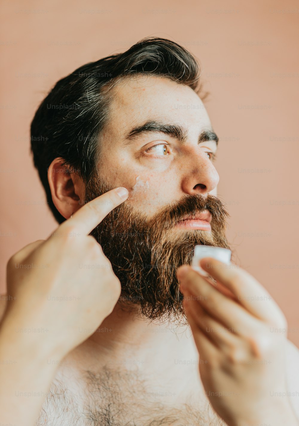 um homem com barba está escovando os dentes