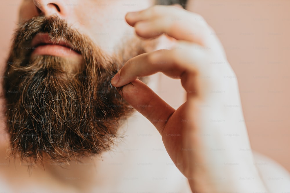 a man is shaving his beard with a comb