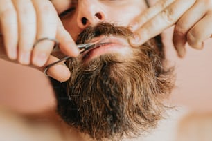 a man is cutting his hair with a pair of scissors