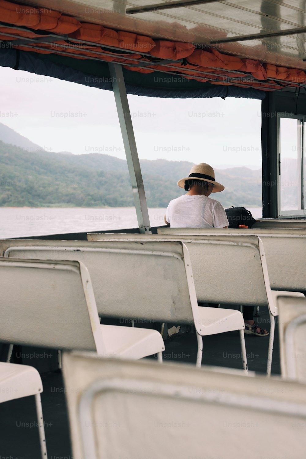 Un homme au chapeau assis sur un bateau