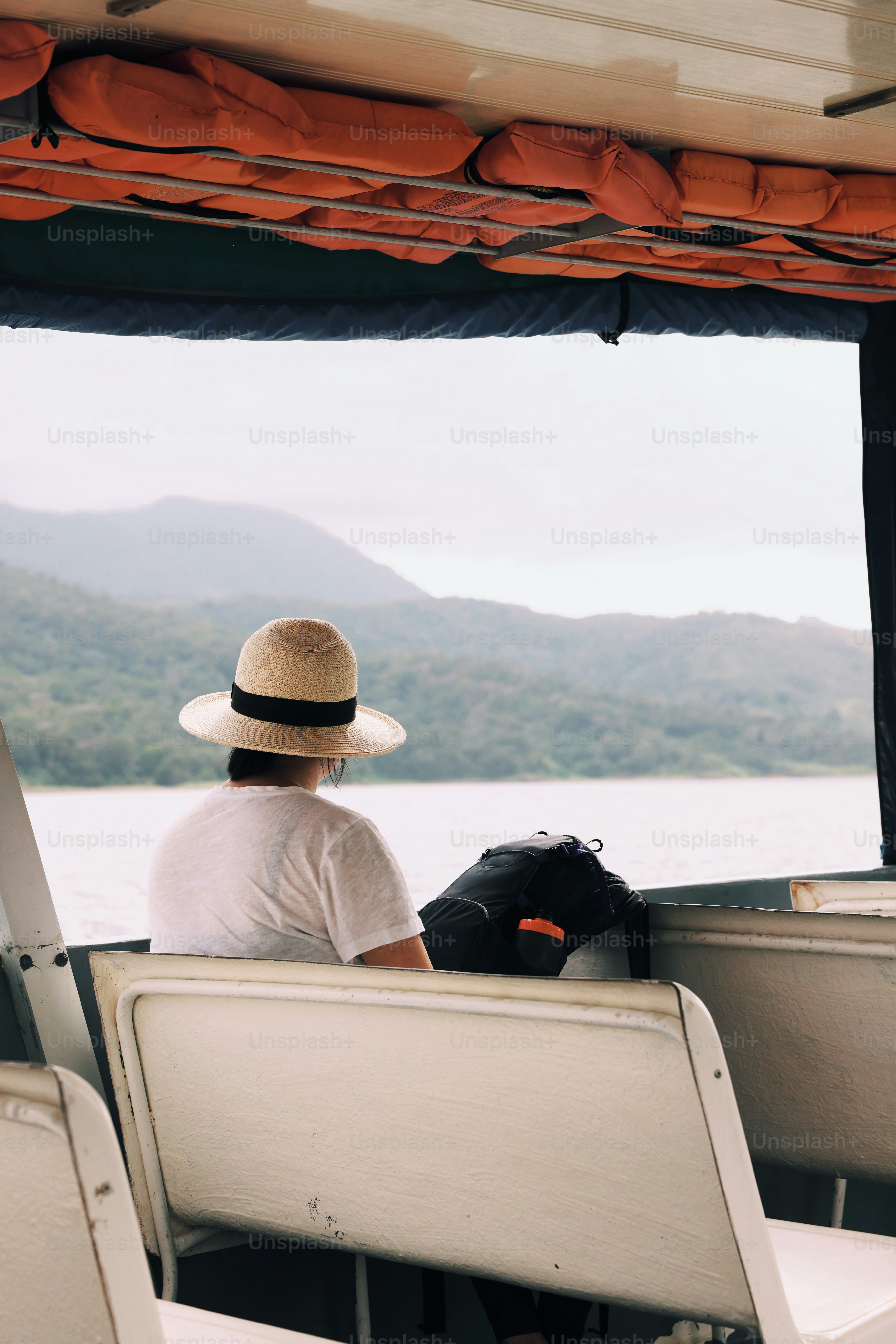 Un hombre con sombrero sentado en un bote foto – Imagen de Viajar en ...