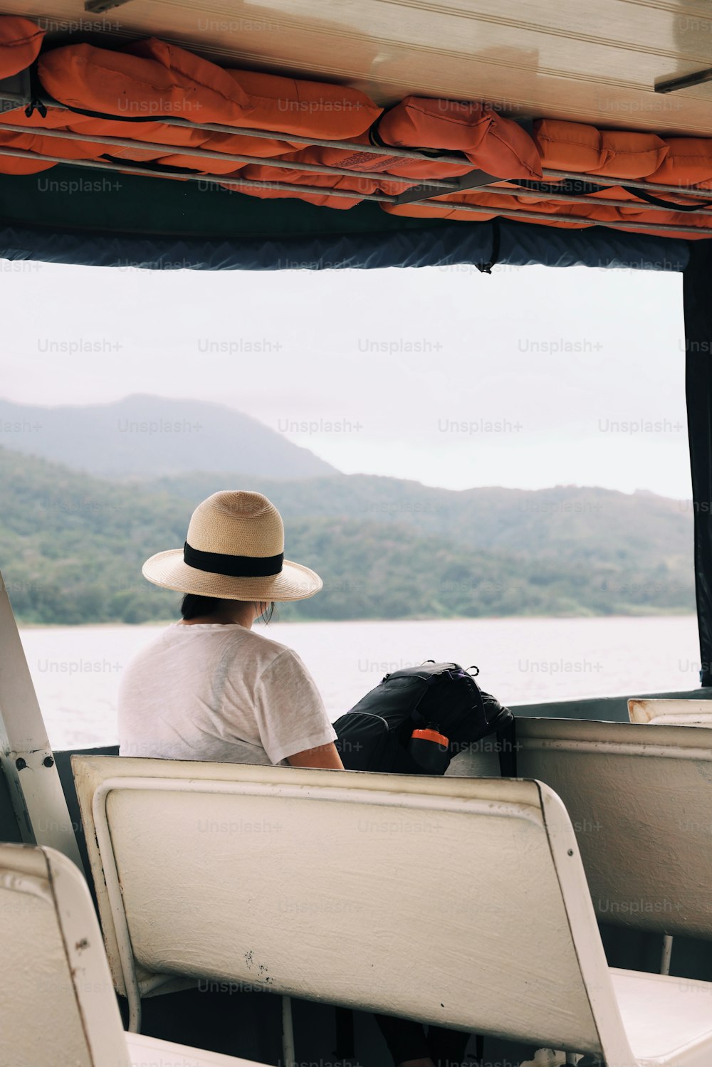 Un homme au chapeau assis sur un bateau