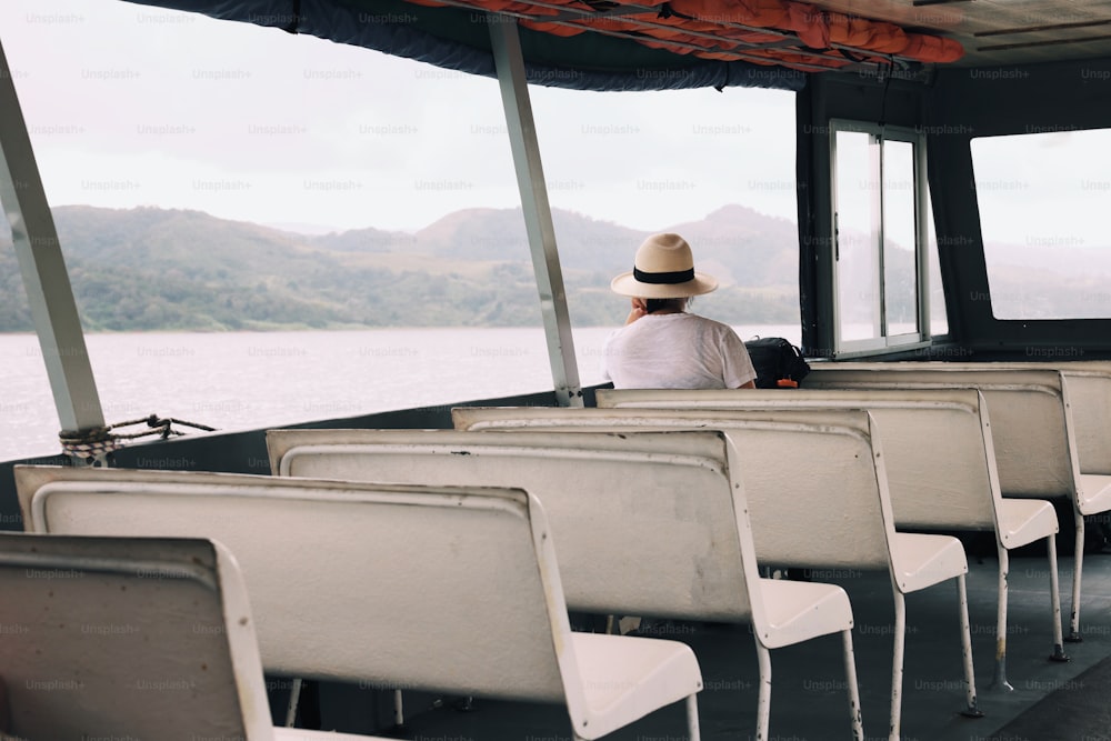 a person sitting on a boat with a hat on