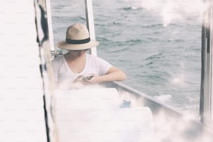 a woman sitting on a boat looking at her cell phone
