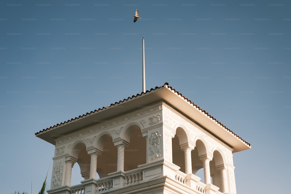 a tall white building with a flag on top of it