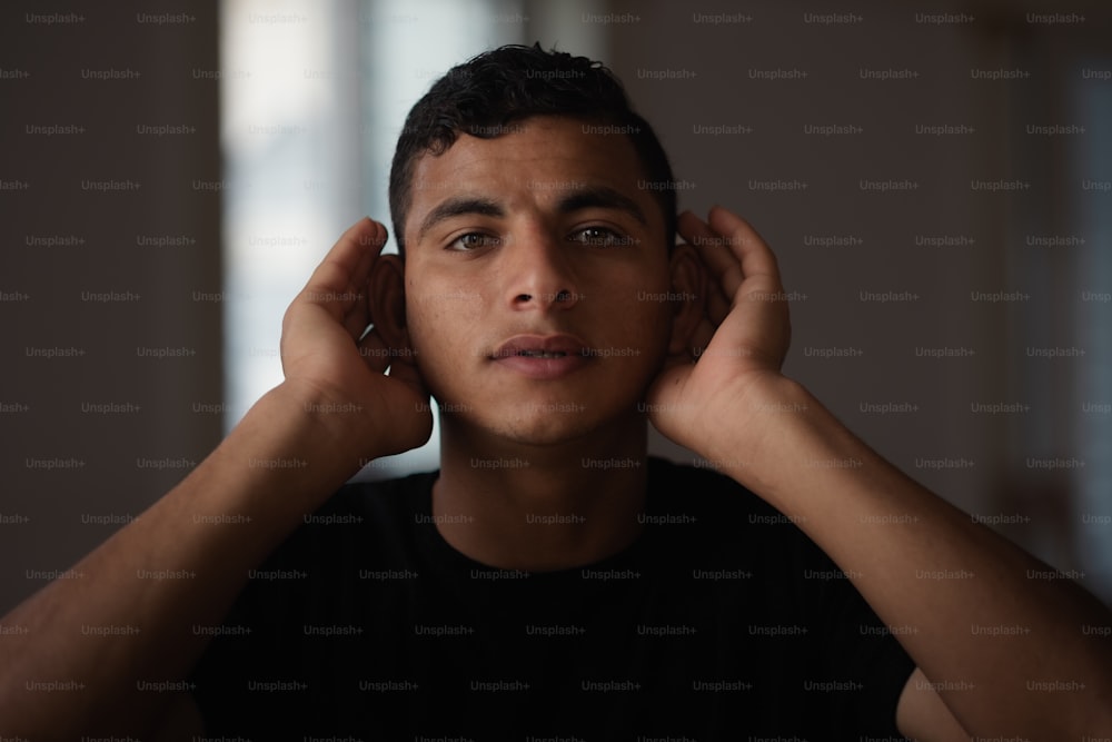 a young man is listening to music with his hands