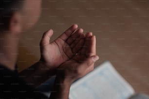 Un hombre está orando con las manos cruzadas