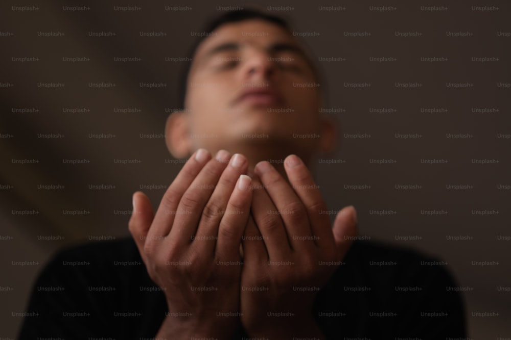 Un hombre está orando con las manos juntas