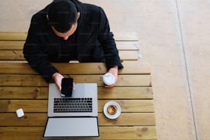 a man sitting at a table using a laptop computer