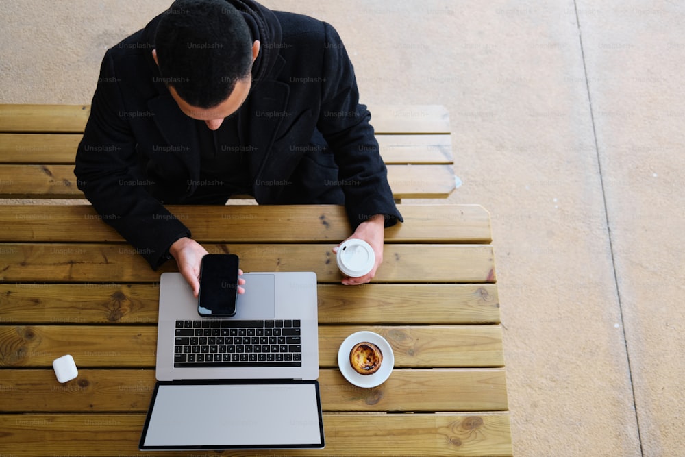 Un hombre sentado en una mesa usando una computadora portátil