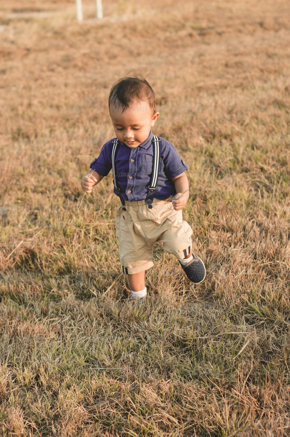 Un petit garçon qui se tient dans l’herbe